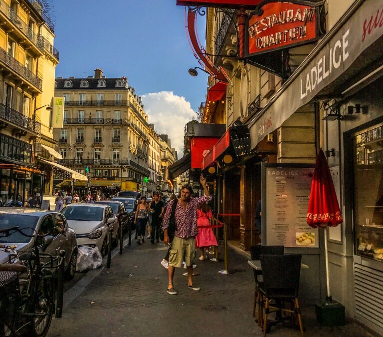 Straat in Parijs met man die op eem neon pijl naar een restaurant wijst