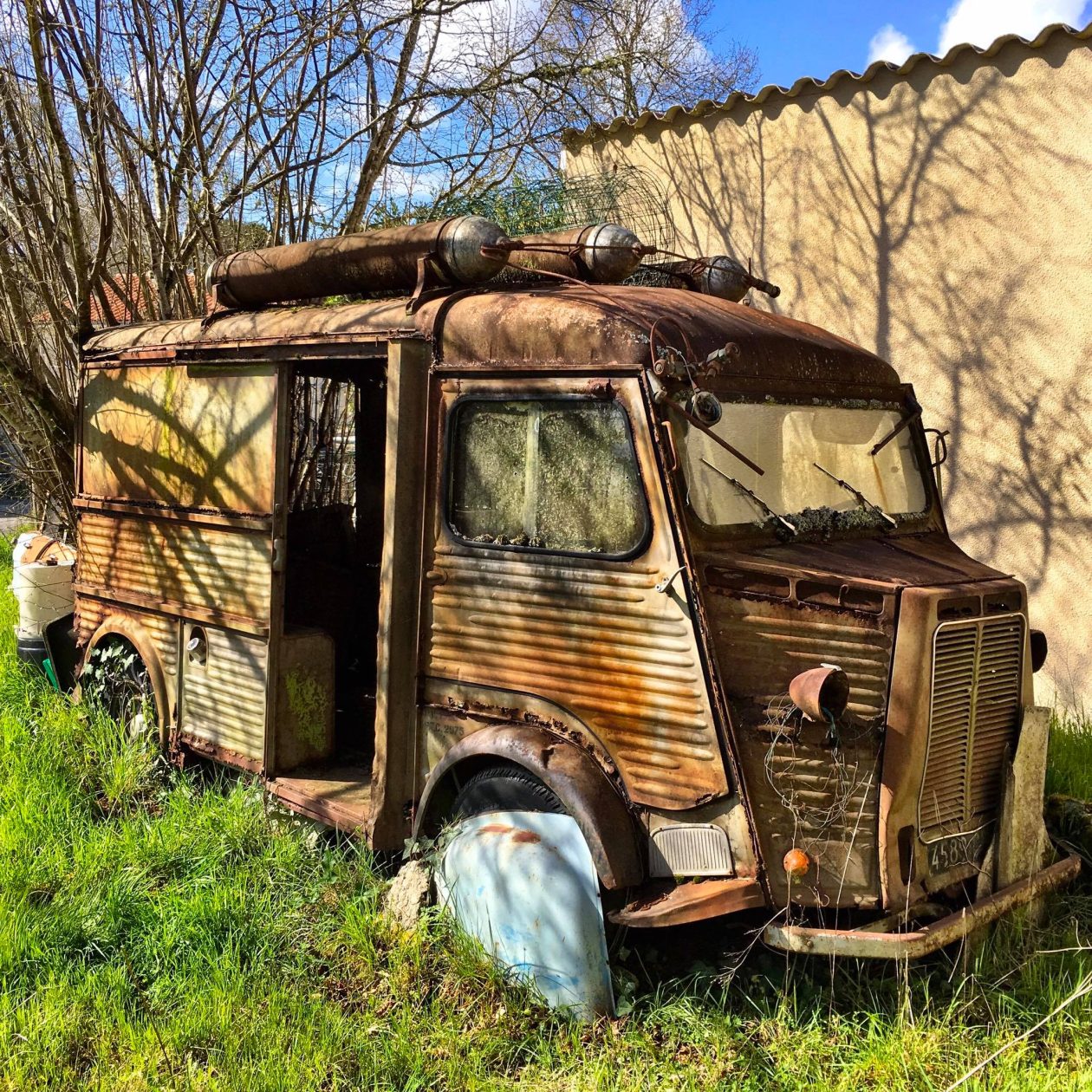 Oude en roestige Citroen HY bus in een tuin
